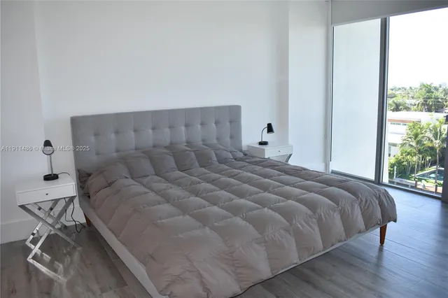 a large bed sitting in a bedroom next to a window