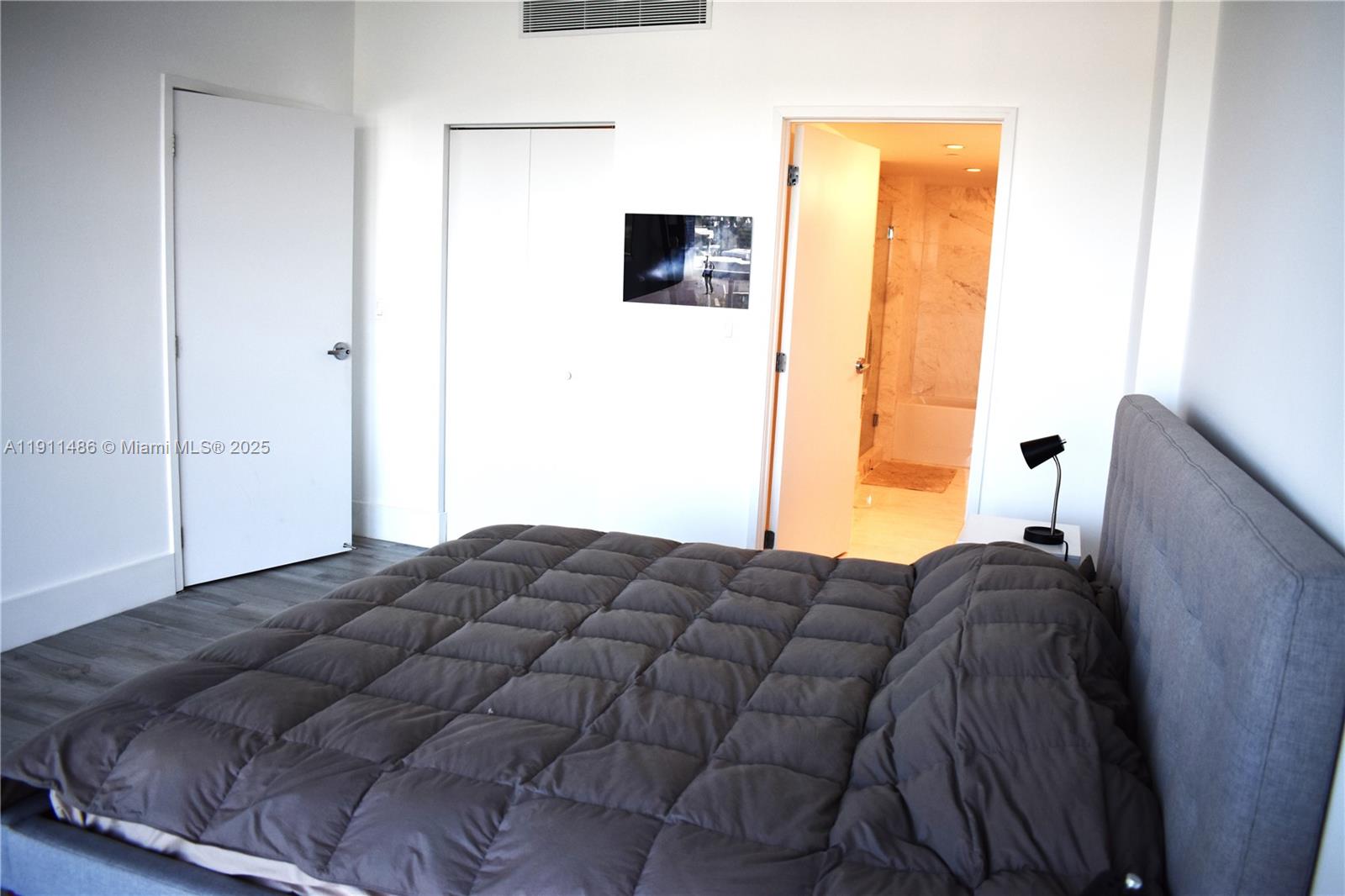 9940 West Bay Harbor Drive, Unit 6DN Bay Harbor Islands, FL 33154 - Photo 20 of 46 a bed room with a bed and a television