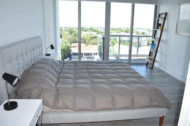 a bedroom with a bed and a large window