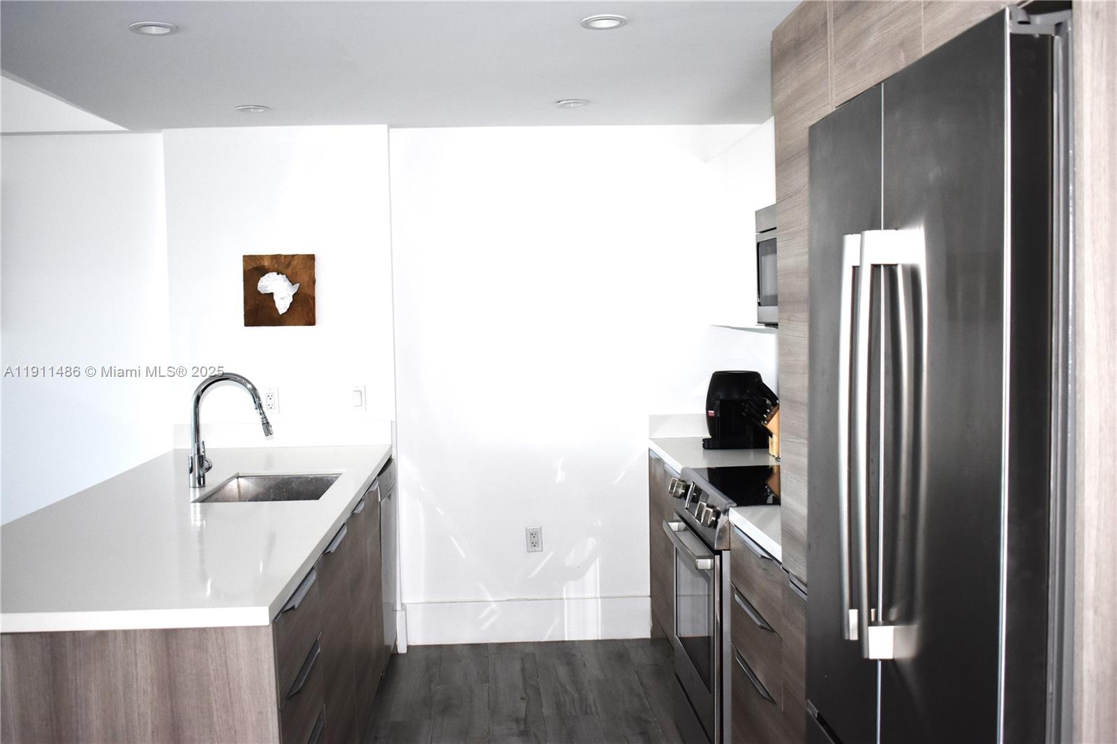 9940 West Bay Harbor Drive, Unit 6DN Bay Harbor Islands, FL 33154 - Photo 8 of 46 a kitchen with a sink and a refrigerator