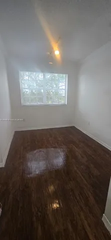 a view of wooden floor and windows in a room