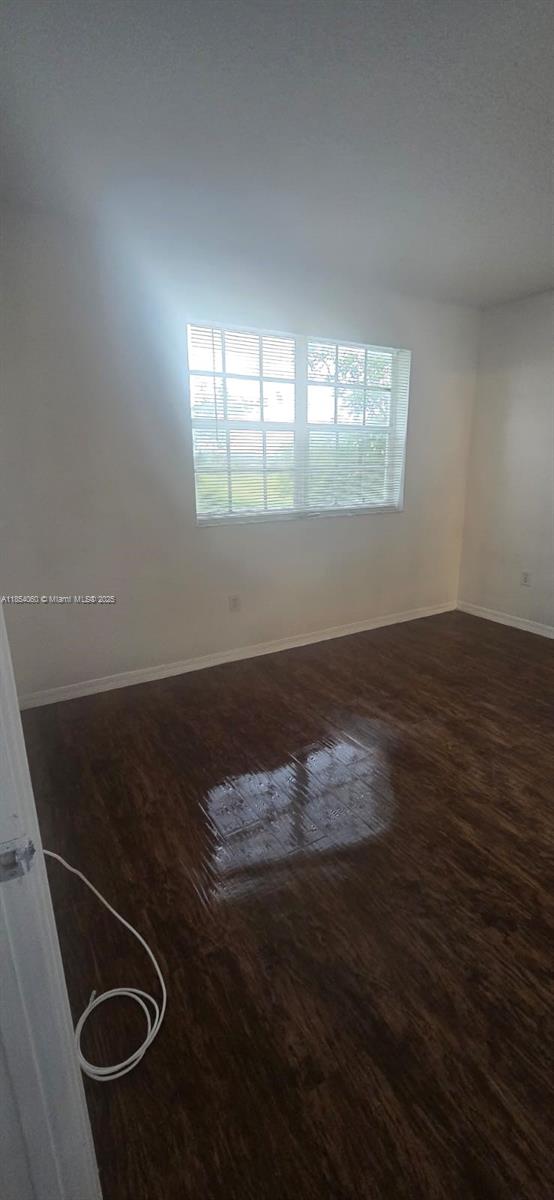 11630 Southwest 2nd Street, Unit 17208 Pembroke Pines, FL 33025 - Photo 26 of 32 an empty room with wooden floor and windows