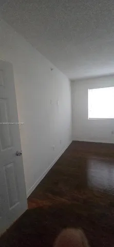 a view of wooden floor and windows in a room