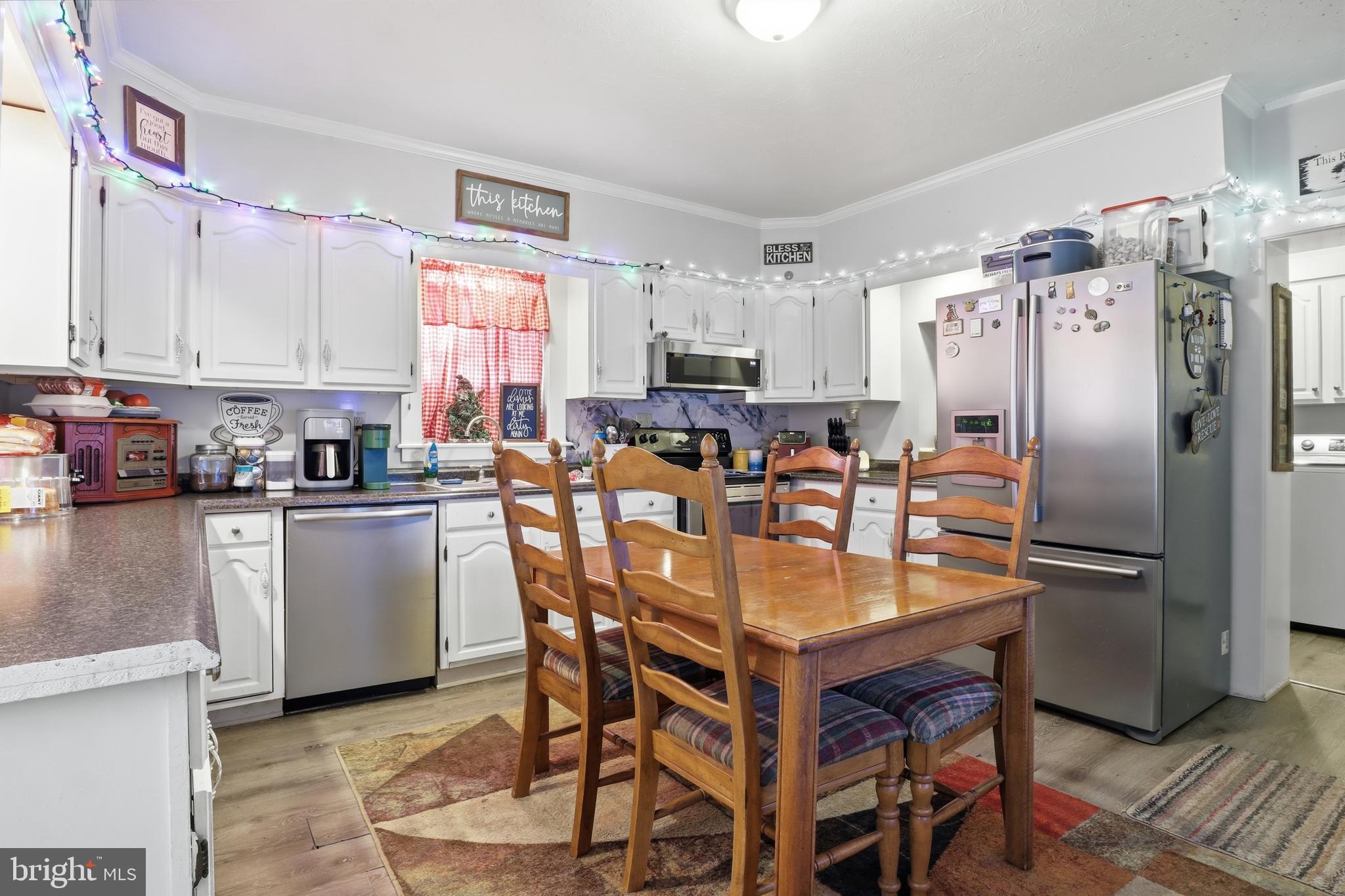 70 North Main Street Dover, PA 17315 - Photo 7 of 43 a kitchen with stainless steel appliances granite countertop a dining table chairs refrigerator and cabinets