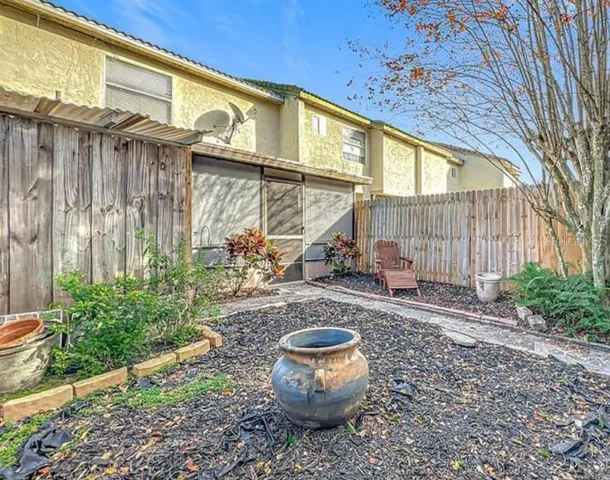 a view of a chairs and table in the back yard of the house