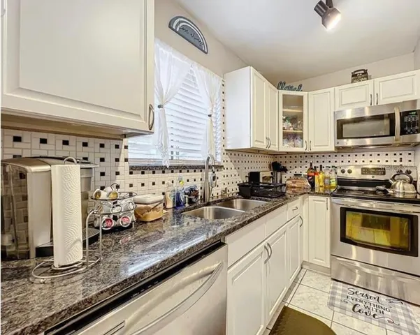 a kitchen with stainless steel appliances granite countertop a sink stove and cabinets