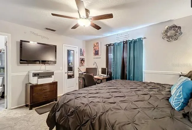 a bedroom with a bed and a flat screen tv