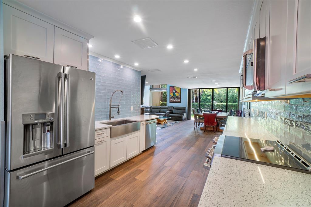 3908 South Ocean Boulevard, Unit TH4 Boca Raton, FL 33487 - Photo 12 of 37 a kitchen with sink refrigerator and microwave