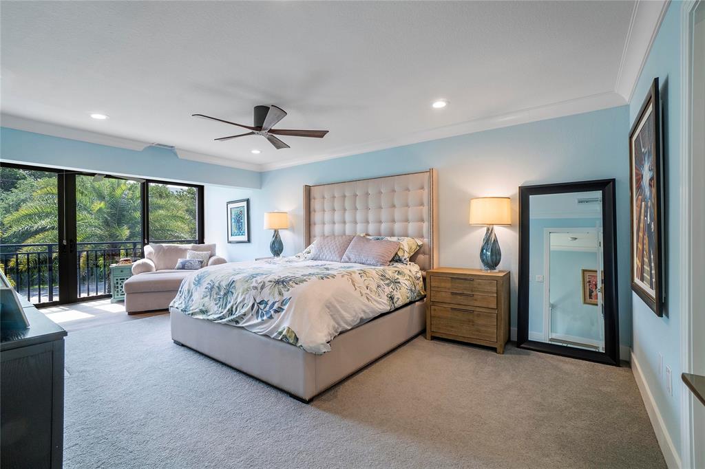 3908 South Ocean Boulevard, Unit TH4 Boca Raton, FL 33487 - Photo 16 of 37 a spacious bedroom with a large bed and a chandelier