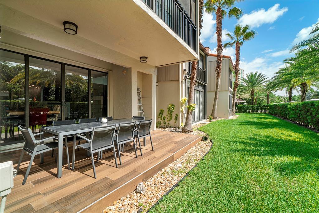 3908 South Ocean Boulevard, Unit TH4 Boca Raton, FL 33487 - Photo 26 of 37 a view of a patio with table and chairs potted plants and floor to ceiling window