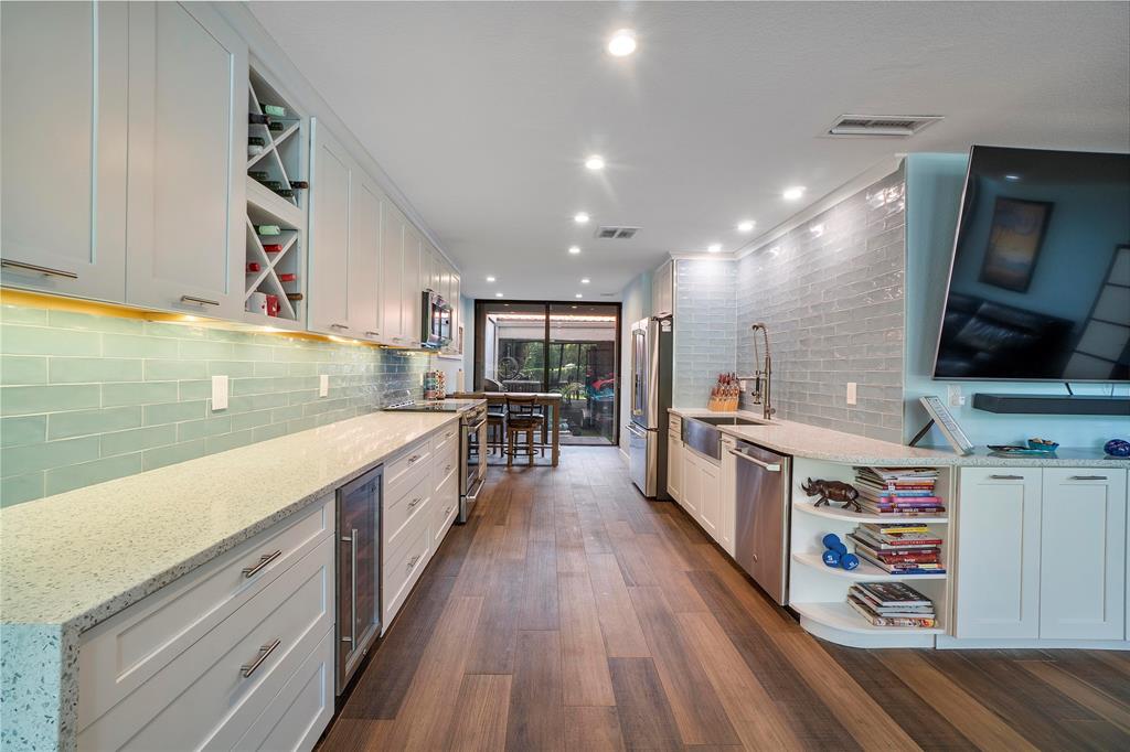 3908 South Ocean Boulevard, Unit TH4 Boca Raton, FL 33487 - Photo 10 of 37 a large white kitchen with stainless steel appliances