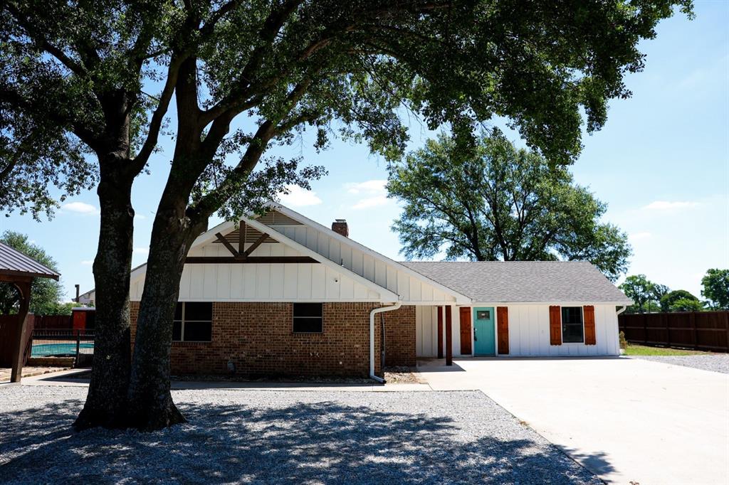 10575 Friendship Road Pilot Point, TX 76258 - Photo 16 of 32 Brick and white horizontal siding exterior with a prominent aqua front door