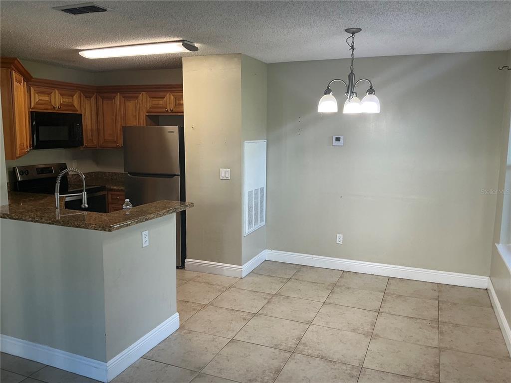 715 Sugar Bay Way, Unit 107 Lake Mary, FL 32746 - Photo 5 of 48 a view of a kitchen with granite countertop stainless steel appliances a sink dishwasher a refrigerator and a counter top