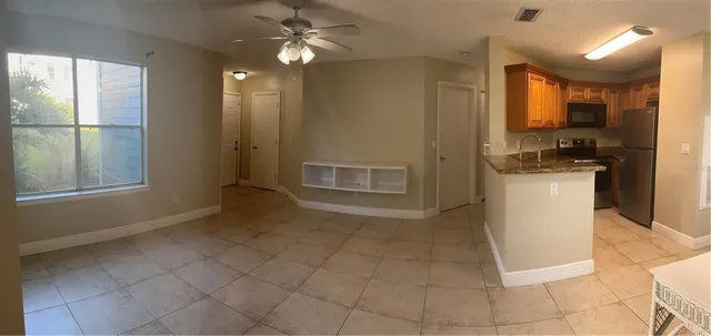 a view of a kitchen with furniture and stainless steel appliances