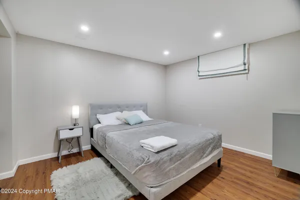 a bedroom with a bed and wooden floor