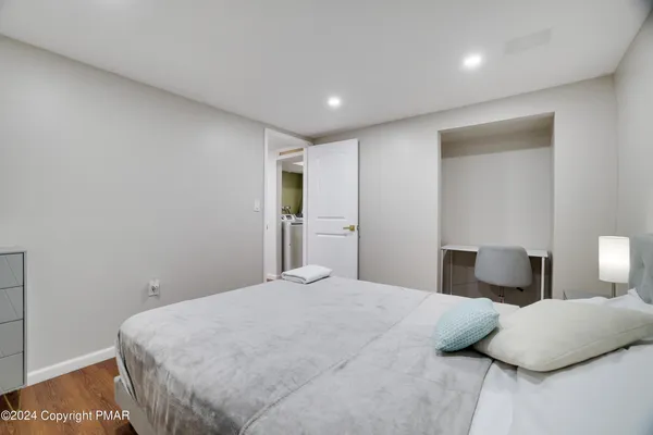 a spacious bedroom with a bed and a lamp