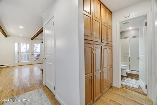 a view of a hallway with wooden floor and windows