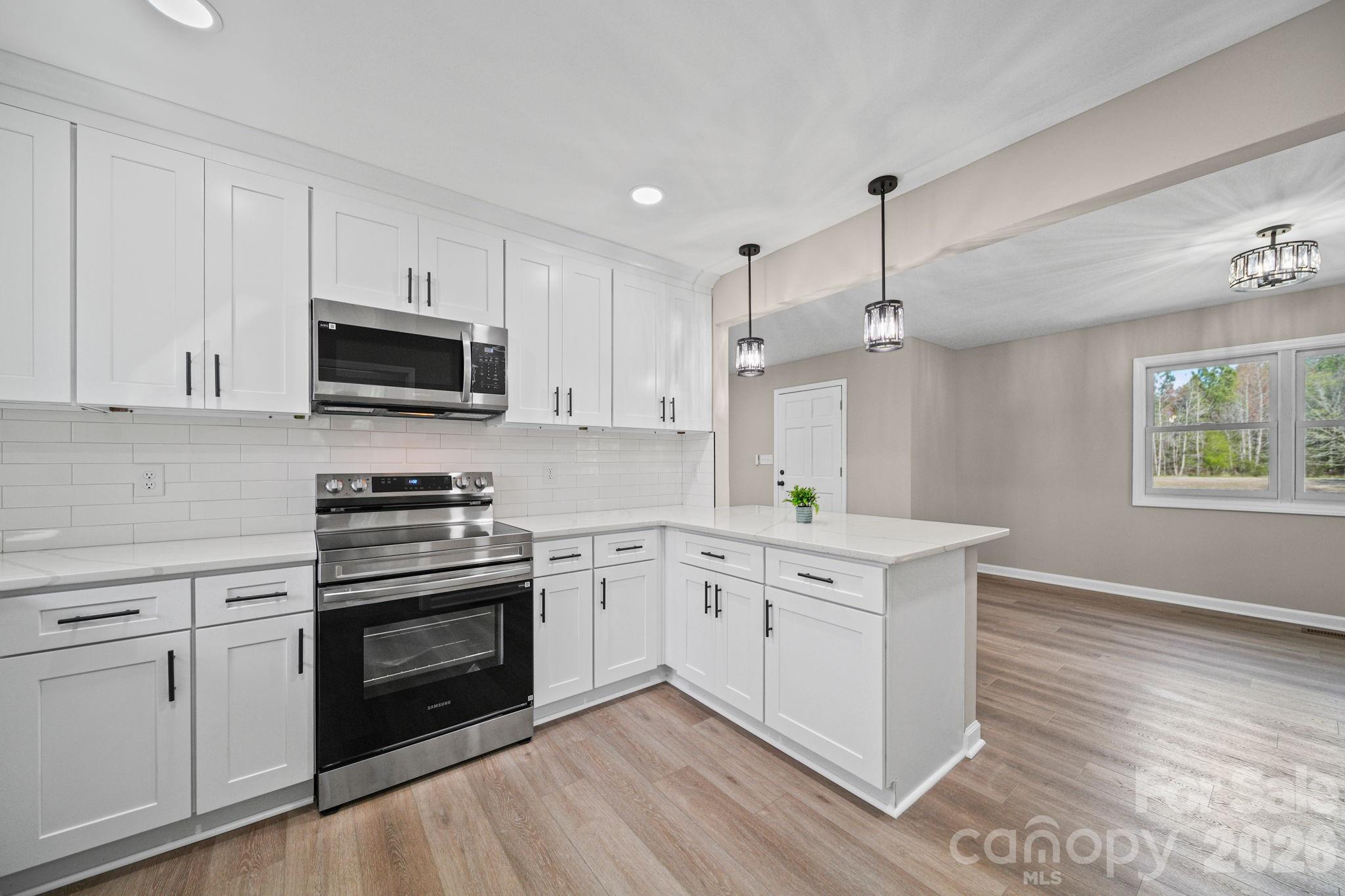 5808 Flint Ridge Marshville, NC 28103 - Photo 13 of 38 a kitchen with stainless steel appliances white cabinets a sink and a stove