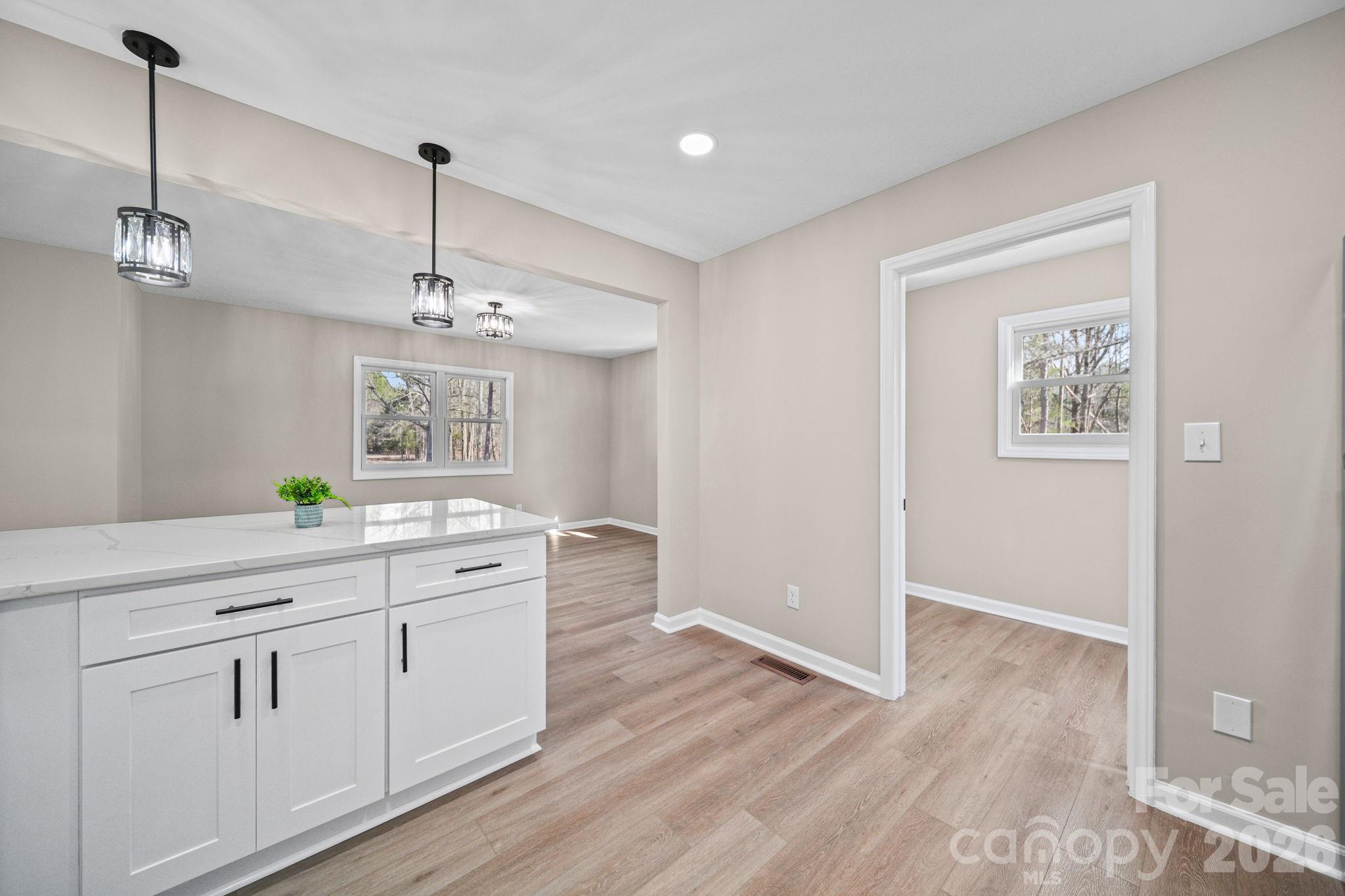 5808 Flint Ridge Marshville, NC 28103 - Photo 15 of 38 a view of a kitchen with a sink wooden floor and a chandelier