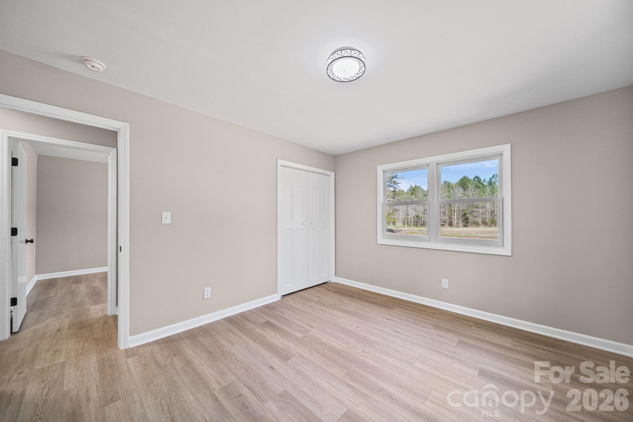 5808 Flint Ridge Marshville, NC 28103 - Photo 21 of 38 a view of an empty room with wooden floor and a window
