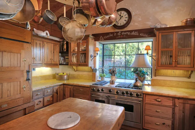 a kitchen with stainless steel appliances granite countertop a sink a stove and a wooden cabinets