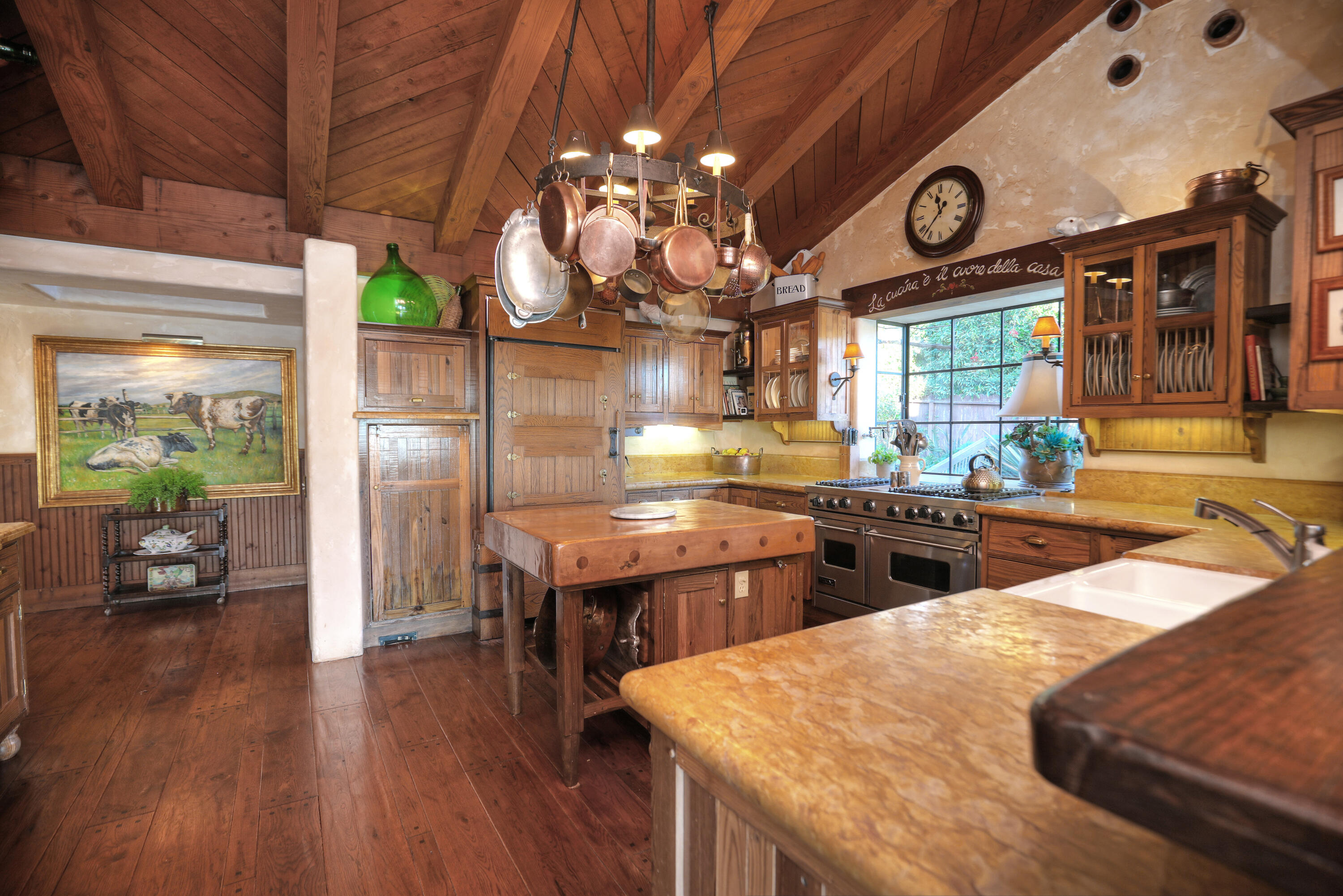 7 Creciente Drive Santa Barbara, CA 93110 - Photo 8 of 16 a kitchen with stainless steel appliances kitchen island granite countertop a table chairs in it and wooden floor