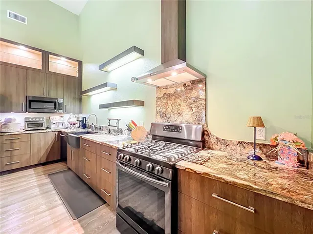 a kitchen with a sink a stove and chairs