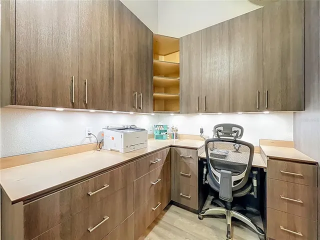 a view of a workspace with furniture and a window