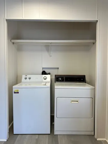 an empty room with wooden floor chandelier fan and windows