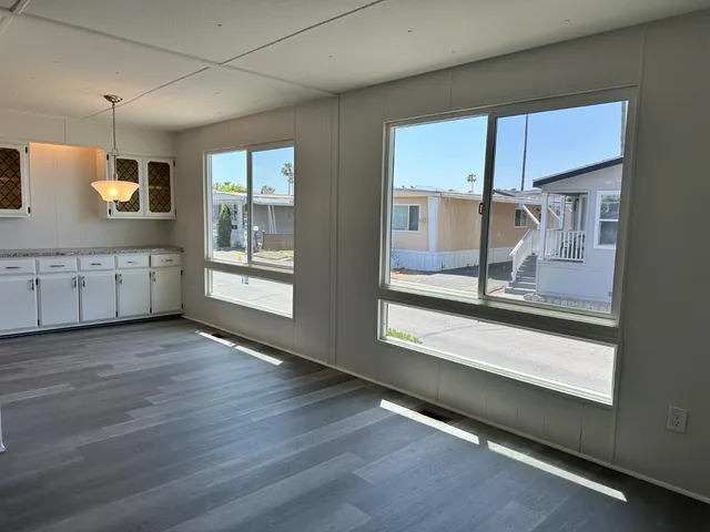 a view of a large kitchen with wooden floor and a window