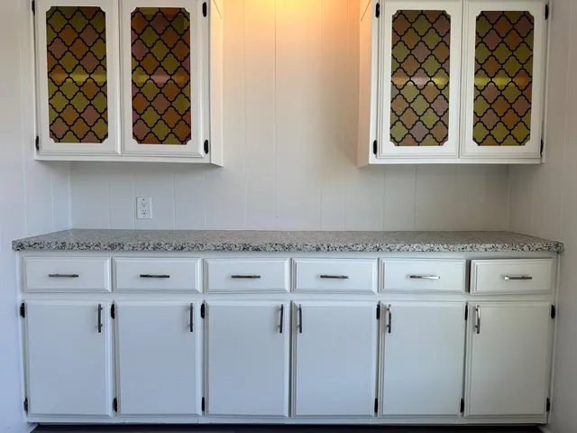 a kitchen with granite countertop a sink stainless steel appliances wooden floor and cabinets