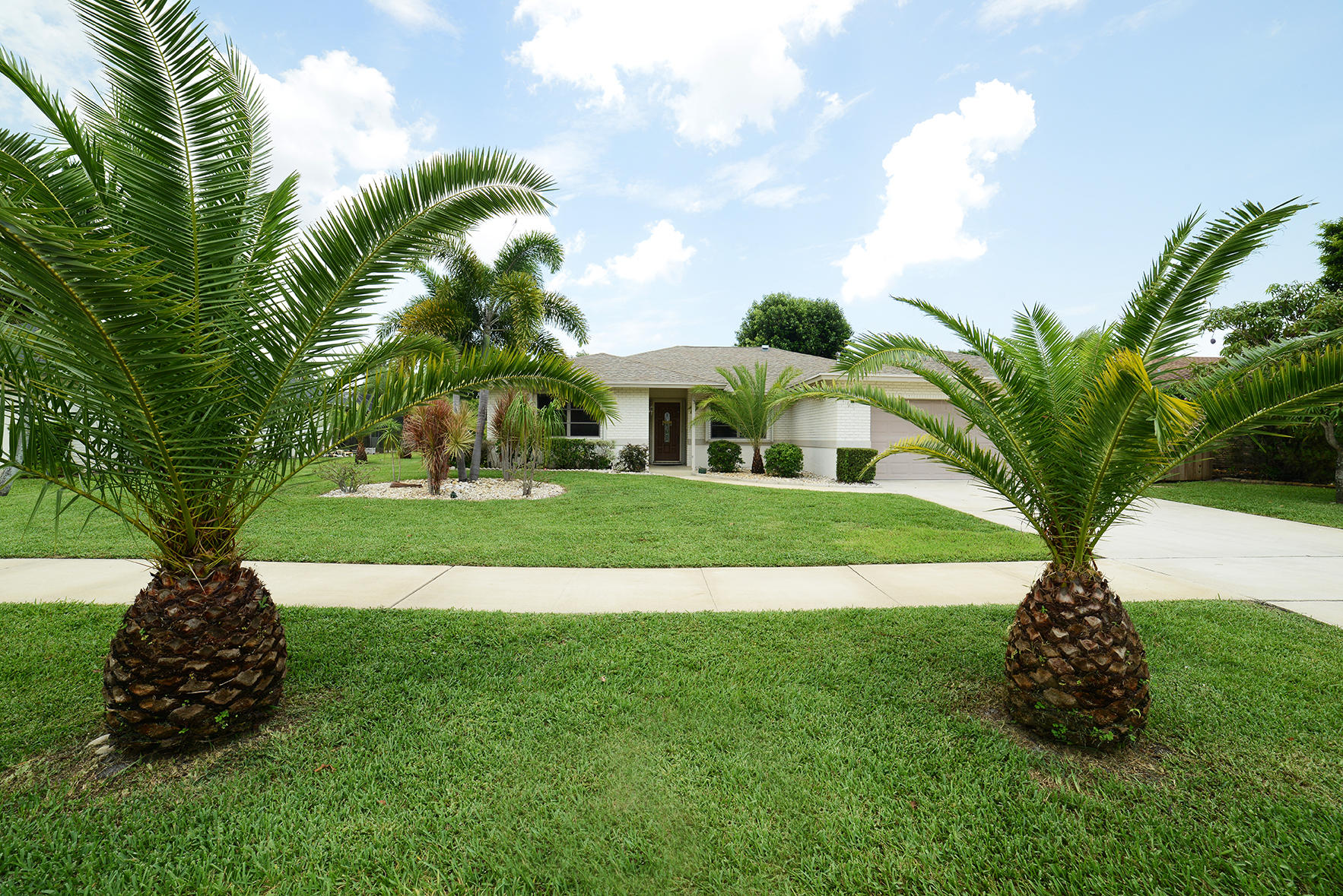 17290 Lake Park Road Boca Raton, FL 33487 - Photo 1 of 28 a view of a white house with a big yard and potted plants