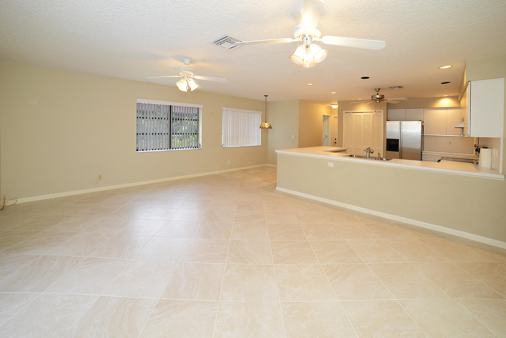 17290 Lake Park Road Boca Raton, FL 33487 - Photo 8 of 28 an empty room with chandelier fan and windows