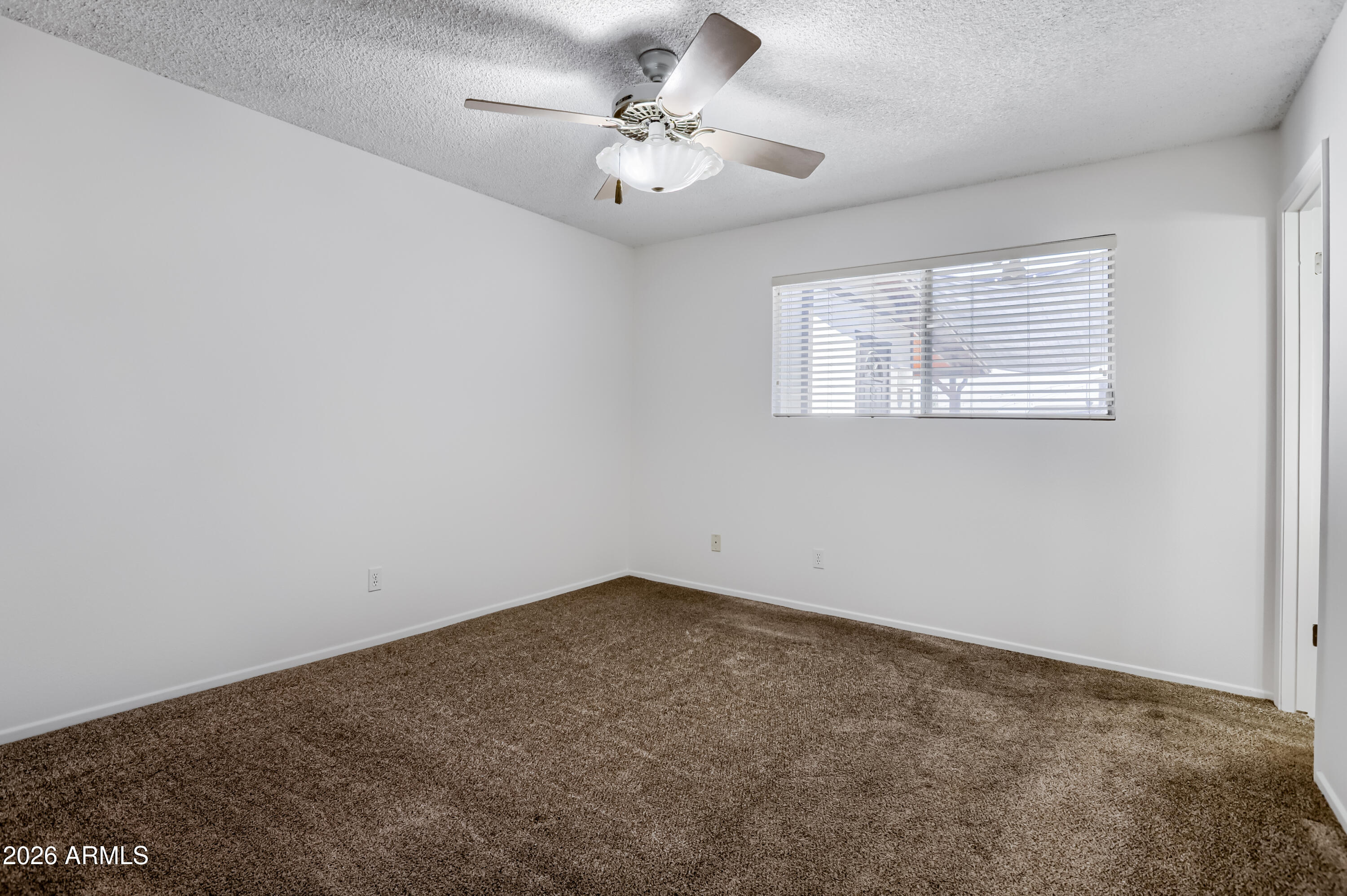 3823 West Greenway Road Phoenix, AZ 85053 - Photo 15 of 28 an empty room with windows and ceiling fan