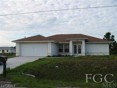 4005 1st Street Southwest Lehigh Acres, FL 33976 - Photo 1 of 5 a front view of a house with garden