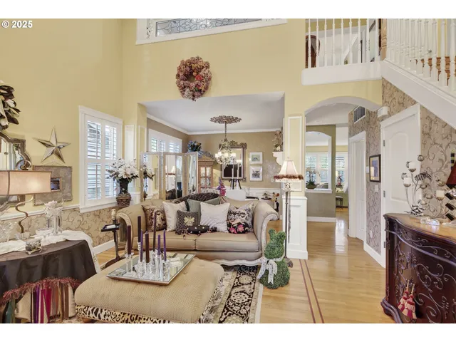 a view of a dining room with furniture a chandelier and large windows