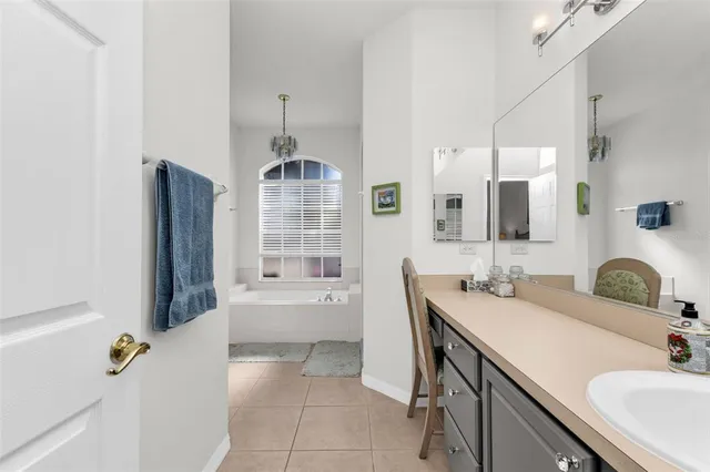 a bathroom with a tub sink and mirror