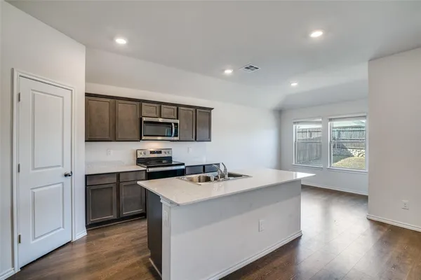 a kitchen with stainless steel appliances a sink stove and microwave