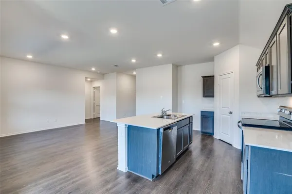 a kitchen with stainless steel appliances granite countertop a sink stove and wooden floor