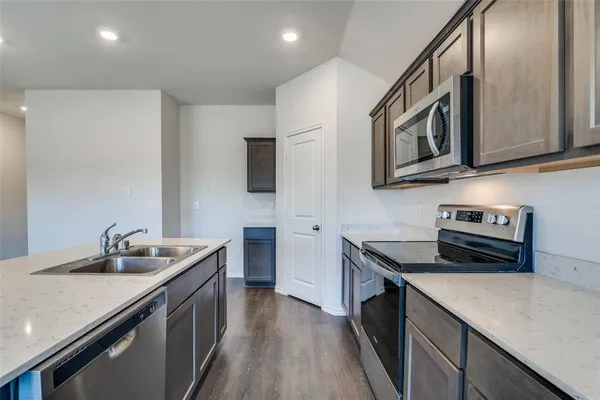 a kitchen with stainless steel appliances granite countertop a sink stove and microwave