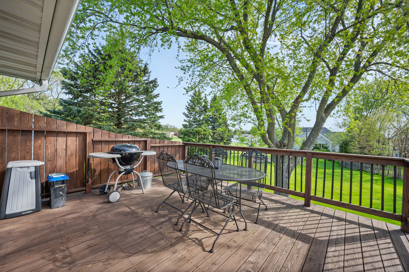 1420 Highland Road Rochelle, IL 61068 - Photo 9 of 30 a view of a deck with chairs a barbeque and a trees with wooden fence