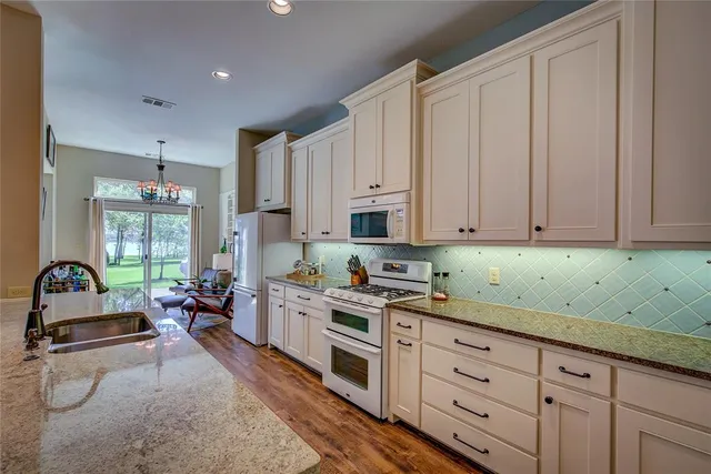 a kitchen filled with white cabinets and white appliances