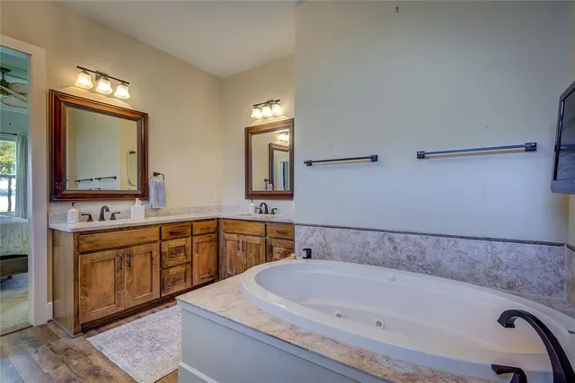 a bathroom with a bathtub sink and mirror
