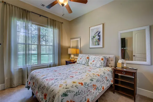 a bedroom with a large bed and a chandelier