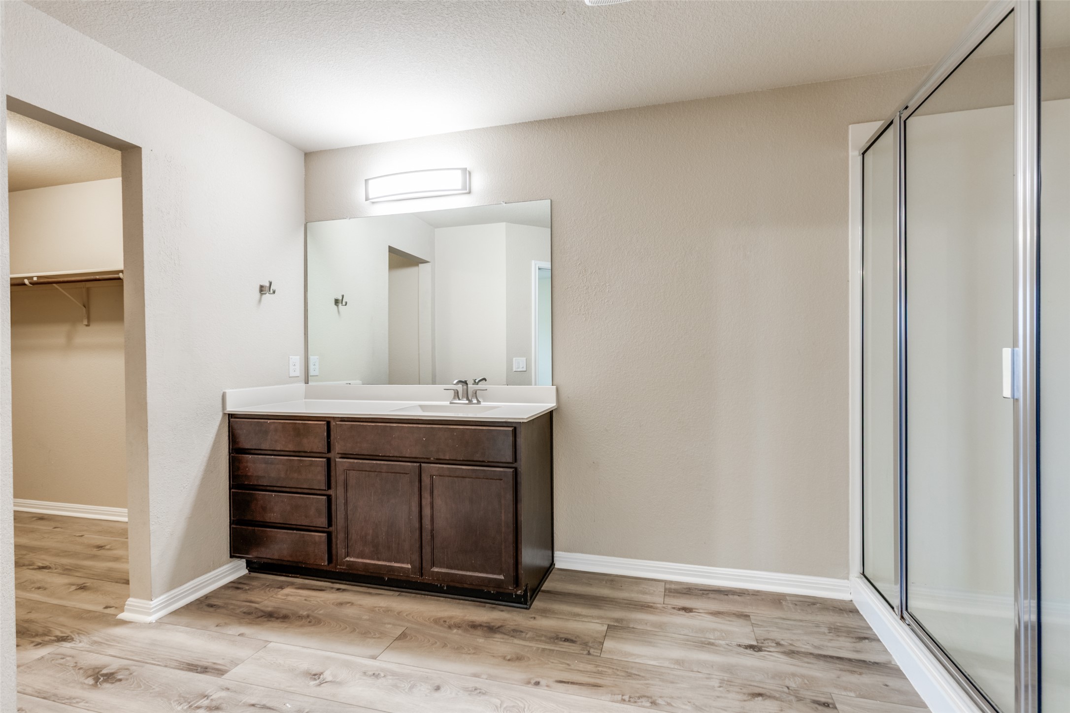 2909 Centrum Drive Austin, TX 78754 - Photo 21 of 30 Bathroom featuring a dark wood vanity with a white countertop and a framed mirror, a separate shower with a glass enclosure, and light-toned flooring