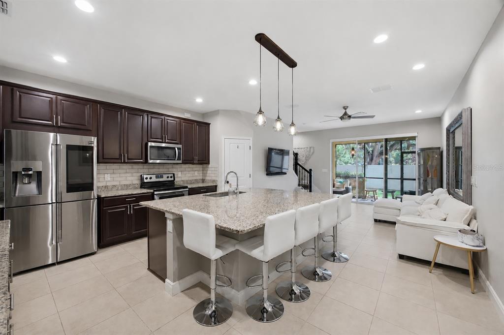 2013 Sunset Wind Loop Oldsmar, FL 34677 - Photo 4 of 43 a large kitchen with a table chairs refrigerator and microwave