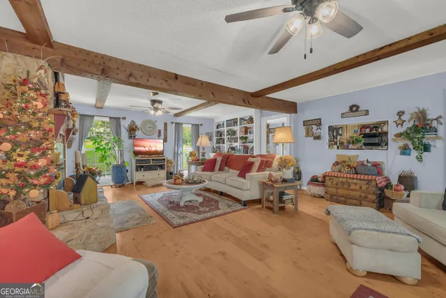 a bedroom with a bed table flowerpot and window