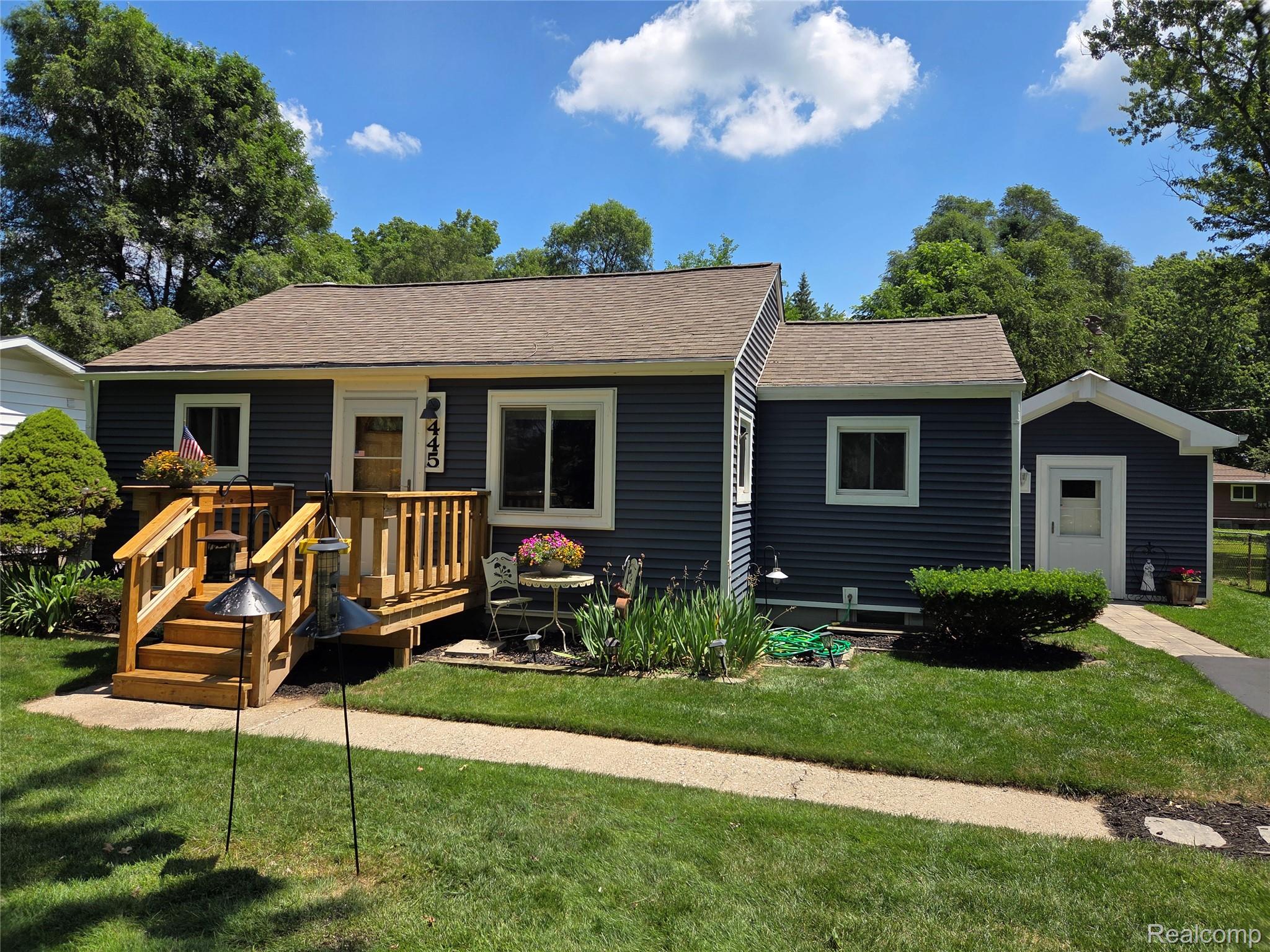 445 Clark Road Highland, MI 48357 - Photo 1 of 7 Blue horizontal siding exterior with white trim and a brown shingle roof