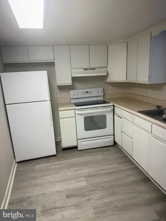 a kitchen with a sink a stove and cabinets