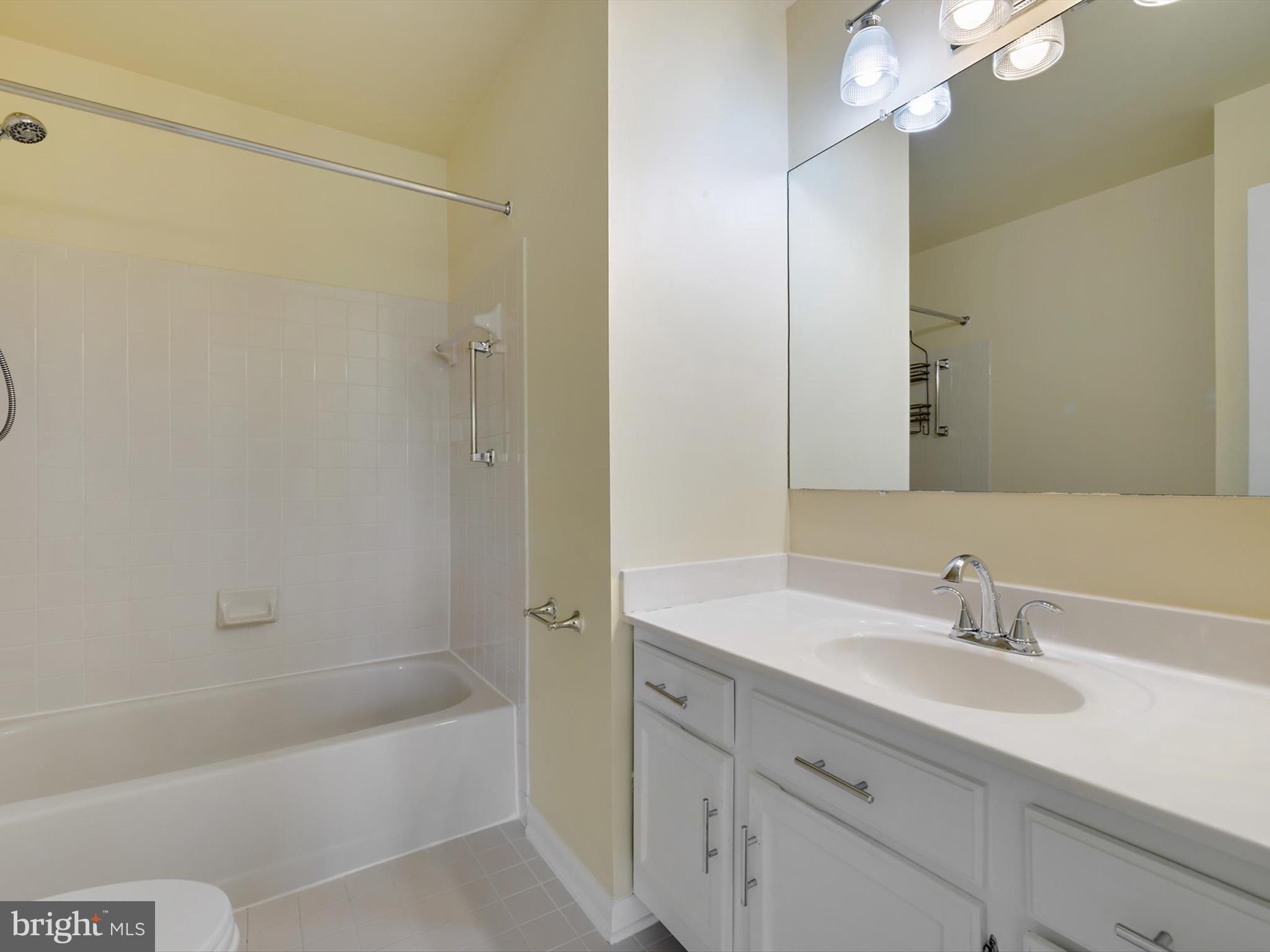 2846 Schoolhouse Circle Silver Spring, MD 20902 - Photo 23 of 32 a bathroom with a sink double vanity granite tub shower and a mirror